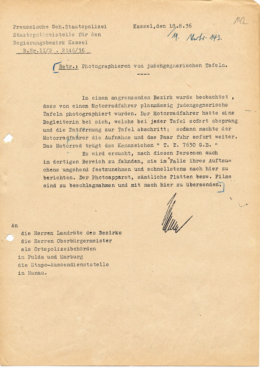 Schreiben der Staatspolizeistelle für den Regierungsbezirk Kassel betreffend Fahndung nach einem Motorradfahrer und dessen Begleitung wegen Fotografierens judengegnerischer Tafeln, 18. August 1936.